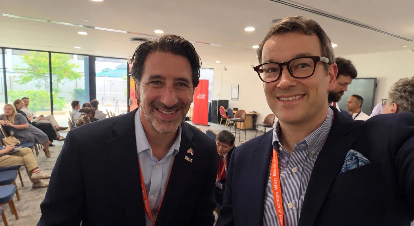 David Stepat, Managing Director of Meridium, smiling beside David Kelly, Executive Director of the British Chamber of Commerce in Singapore, in an event room at the British High Commission, with seated guests behind them