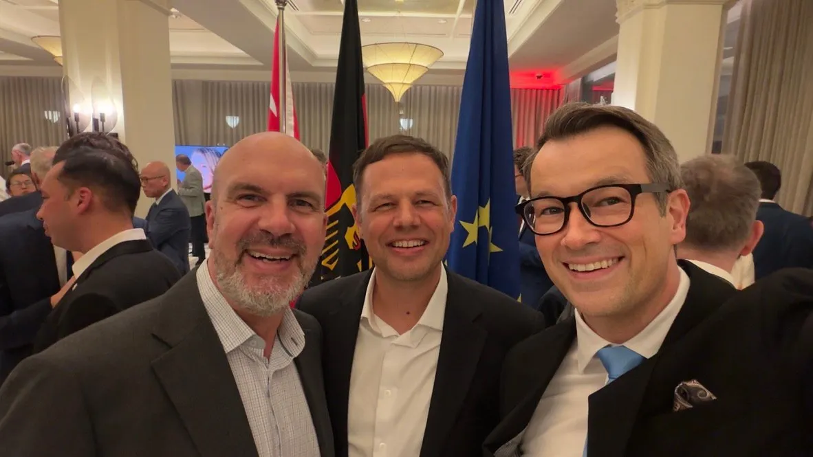 David Stepat with two fellow guests in front of the German and European flags