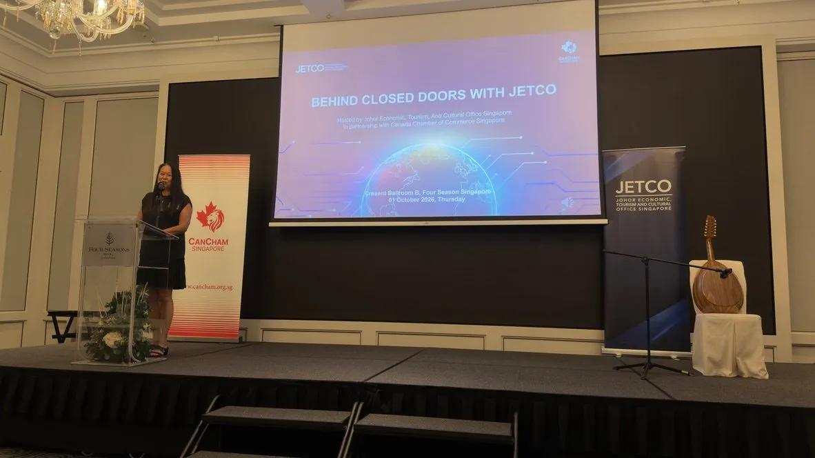 Welcome address at the lectern, with the Behind Closed Doors with JETCO title slide on screen and CanCham and JETCO banners on stage